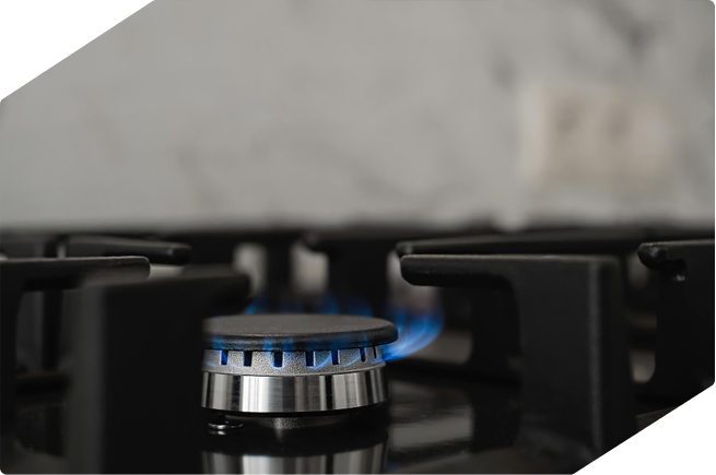 Close-up of a gas stove burner with a blue flame, perfect for cooking with precision and control.