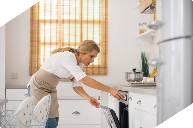 Woman checking oven temperature for cooking.