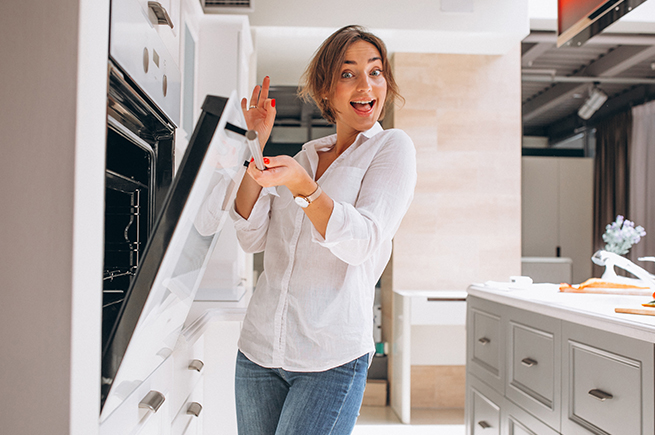 Happy woman exploring kitchen appliances, showcasing tips for selecting the perfect appliance for your home.