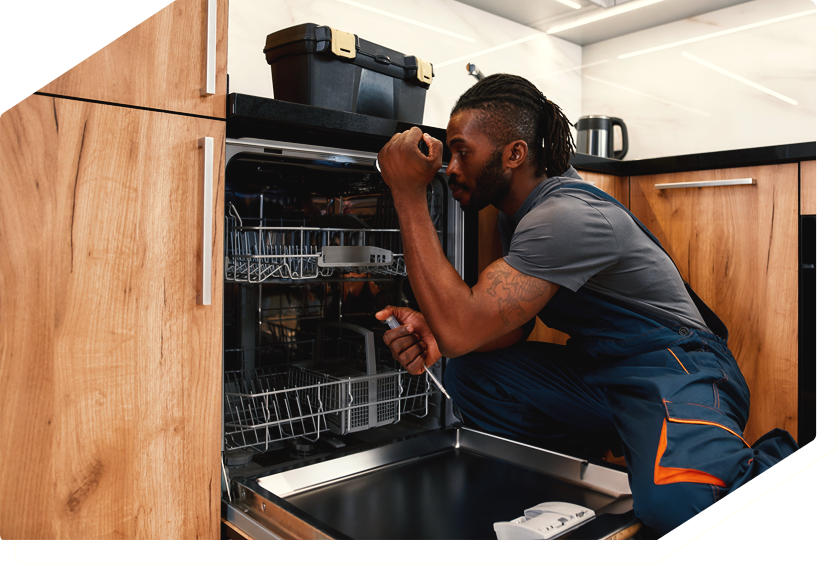 Technician inspecting and repairing a dishwasher, providing professional appliance repair service.