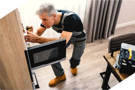 Technician repairing a built-in microwave, providing expert appliance repair service.