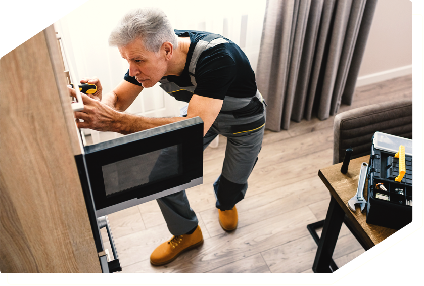 Technician repairing a built-in microwave, providing expert appliance repair service.