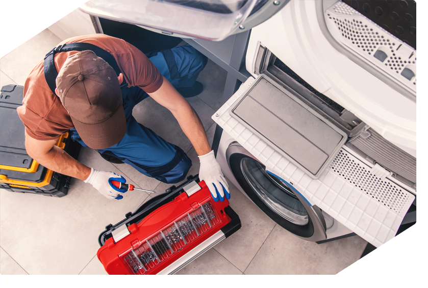 Technician repairing a dryer with a toolbox, providing expert appliance repair service.