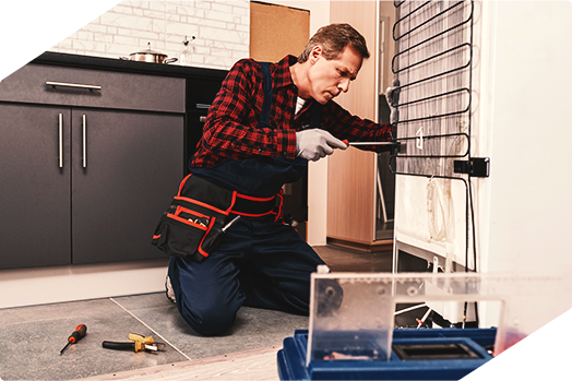 Technician repairing a refrigerator, showcasing professional appliance repair service.